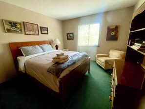 Una camera d'albergo con un letto, una sedia, una scrivania e una finestra.