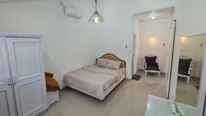 A bedroom with a bed, wardrobe, mirror, and ceiling light. - Cozzy Villa Rans Cimacan (cianjur)