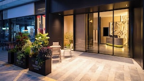 A modern building with a reception area, outdoor seating, and planters. - YEENFON HOTEL (Shenzhen)