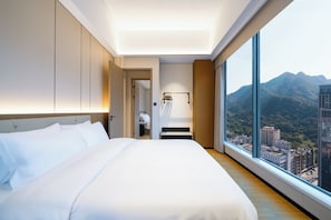 A modern hotel room with a large bed, a walk-in closet, a bathroom, and a city view through large windows. - YEENFON HOTEL (Shenzhen)
