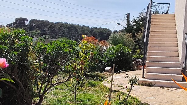 A garden with a staircase leading to a building, surrounded by greenery and a clear sky. - 3-bedroom single-family home, 3 km from the beaches and close to everything: restaurants, movie theater, park, and sports facilities (La Garde)