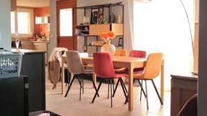 A dining area with a wooden table, chairs, and a vase with flowers. - 3-bedroom single-family home, 3 km from the beaches and close to everything: restaurants, movie theater, park, and sports facilities (La Garde)