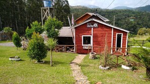 A red wooden cabin with a sign reading 'Recanto BearHead.'