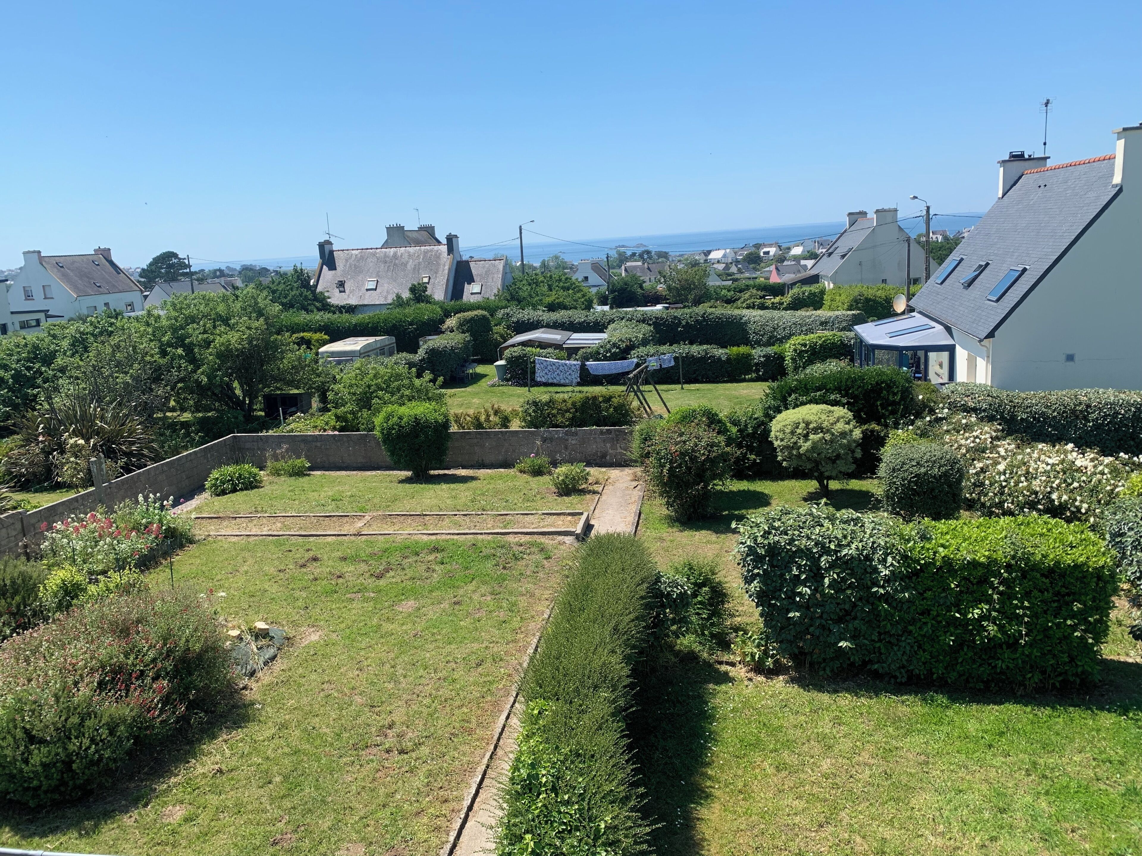 A residential area with houses, a lawn, and a clear sky.