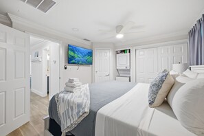 A bedroom with a bed, a television, and a ceiling fan. - Steps to Beach | Family Retreat w/ Community Pool (Indian Shores)
