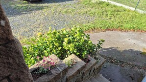 Een stenen trap die uitkomt op een gazon met een haag en bloemen.