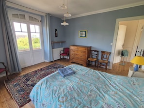 A bedroom with a bed, dresser, chairs, a radiator, and a window with curtains. - Spacious and bright charming house in Trebeurden (Trébeurden)