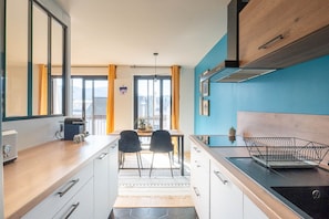 Eine moderne Küche mit Essbereich, großen Fenstern und Blick auf die Stadt.