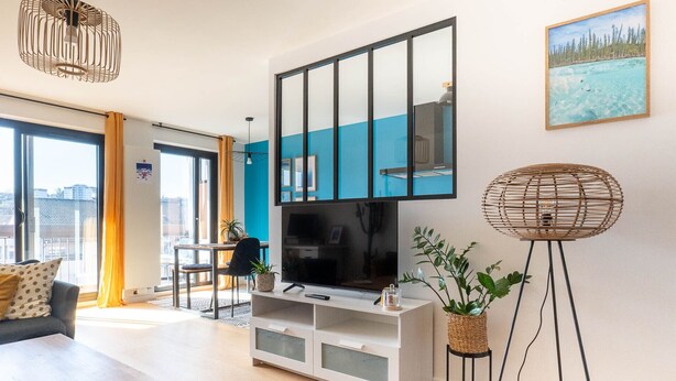 En moderne stue med TV, sofa og spiseplads.