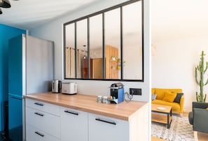 Eine moderne Küche mit einem großen Spiegel, einer Kaffeemaschine und einem Toaster.