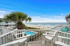 A balcony with a view of the beach and ocean, a pool, and white railings. - Beachfront 3BR/2BA condo in Surfside Beach that sleeps 7.  Direct Beach access (Surfside Beach)
