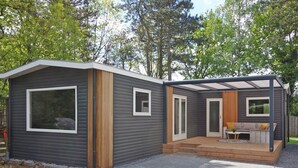 Et moderne hus med to etager og en terrasse.