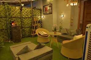 A cozy indoor space with wicker furniture, a small table, and a sofa. - SkyNest stays- A private terrace garden | Near cyber hub  & galleria market |  (Gurugram)