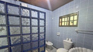 Baño con azulejos azules, inodoro, bidé y lavamanos.