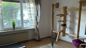 Una stanza con tapis roulant, un tavolino con una pianta, un tappetino da yoga e un ruota per yoga.