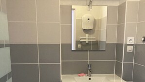 Ein Badezimmer mit einem weißen Waschbecken, einem Spiegel und zwei Schubladen.