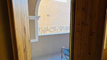 Una stanza con una porta-finestra scorrevole che dà su un patio esterno.
