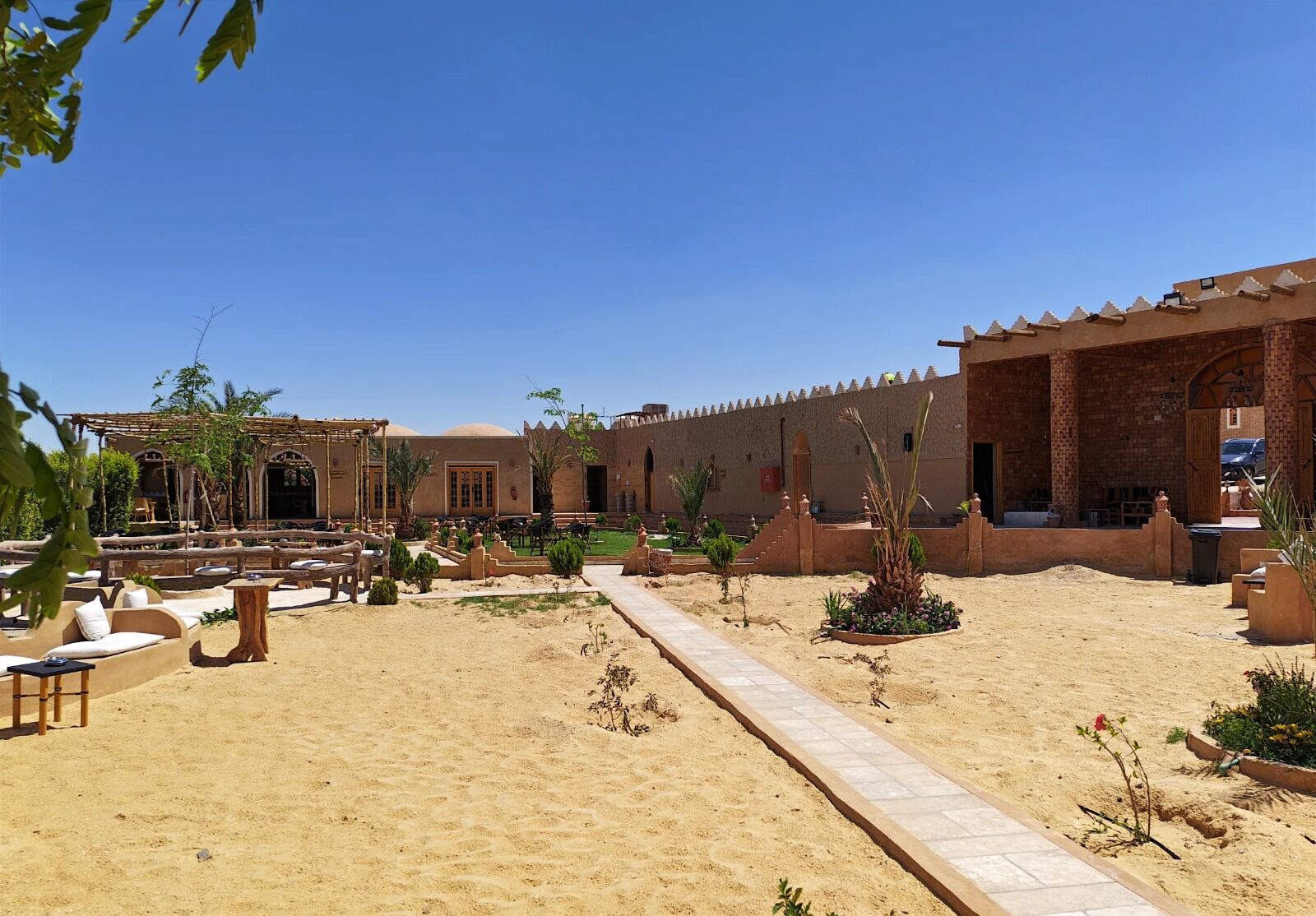 Un cortile con posti a sedere all'aperto, un vialetto e un edificio dal design tradizionale.