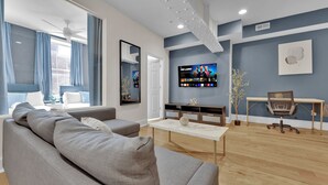 A modern living room with a sofa, TV, and a desk. - Apartment at 117 Chestnut Philadelphia (Philadelphia)