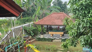 A garden with a pool table, a slide, and exercise equipment. - Cozzy Villa Swasti Cisarua (bogor)