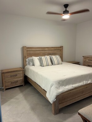 A bedroom with a wooden bed, two nightstands, a ceiling fan, and a bedside table. - PRISTINE CONDO, 1st floor, 2 bed/2 bath, Golfers PARADISE at Calusa Country Club (Lakewood Ranch)