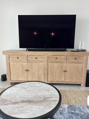 A living room with a TV, wooden cabinet, and a marble table. - PRISTINE CONDO, 1st floor, 2 bed/2 bath, Golfers PARADISE at Calusa Country Club (Lakewood Ranch)