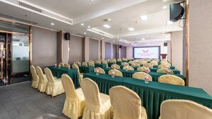 A conference room with rows of tables, chairs, and a projection screen. - Vienna Hotel Guangzhou North Station (Guangzhou)
