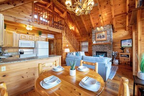 Ein Holzblockhaus-Innenraum mit Küche, Essbereich und Wohnzimmer.