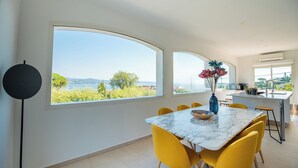 Un comedor moderno con una mesa grande, sillas amarillas y vistas al exterior.