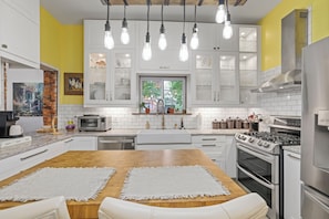A modern kitchen with white cabinets, a wooden countertop, and a built-in oven.