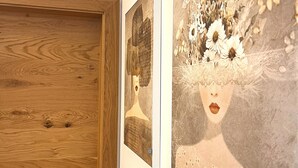 A wooden door with a metal handle and a wall with two framed artworks. - Modern Holiday Home With Sauna (Sankt Lambrecht)