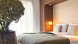 A modern hotel room with a bed, a bedside lamp, and a potted plant. - Modern Holiday Home With Sauna (Sankt Lambrecht)