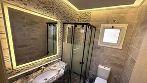 A bathroom with a glass-enclosed shower, a marble sink, and a toilet. - Diarna Latin district Residency (Marsa Matrouh Governorate)