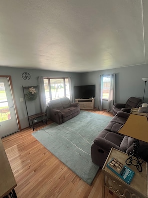 A living room with a sofa, a TV, a coffee table, and a lamp.