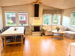 A spacious living room with a fireplace, a dining area, and a sofa.