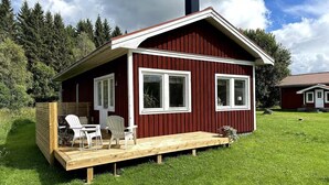 A small red wooden house with a deck, two windows, and a chimney. - Cosy Cottage in Dals-Ed, 3 Min Drive from Moose Ranch & Lakes (Ed)