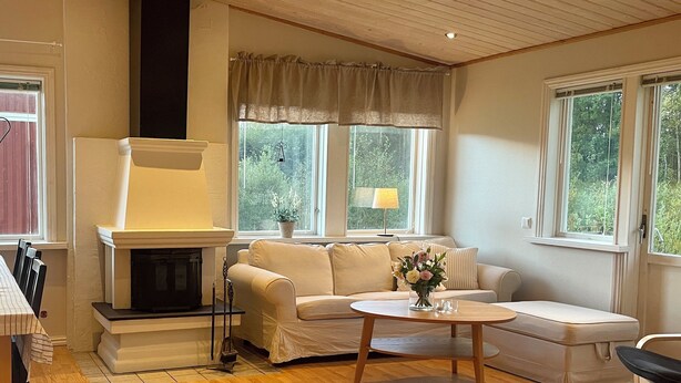 A living room with a fireplace, sofa, coffee table, and windows with curtains. - Cosy Cottage in Dals-Ed, 3 Min Drive from Moose Ranch & Lakes (Ed)
