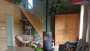 En hyggelig stue med en trappe i træ, en pejs, en sofa og et sofabord.