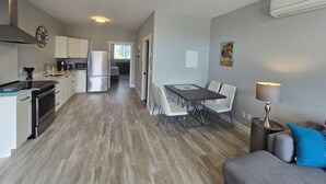 Um apartamento moderno com cozinha, sala de jantar e sala de estar.