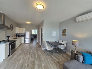 Un appartement moderne comprenant une cuisine, un coin repas et un salon.