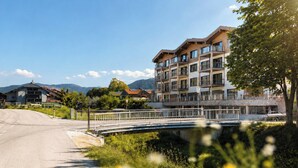 Un edificio de varios pisos con balcones, un puente y una carretera que lo conecta.