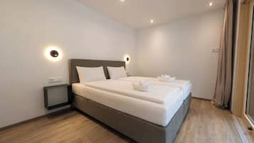 Une chambre moderne avec un grand lit, des tables de chevet et un luminaire au plafond.