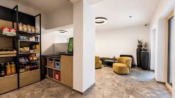 Un intérieur moderne comprenant un espace d’accueil, des sièges et un kiosque en libre-service.
