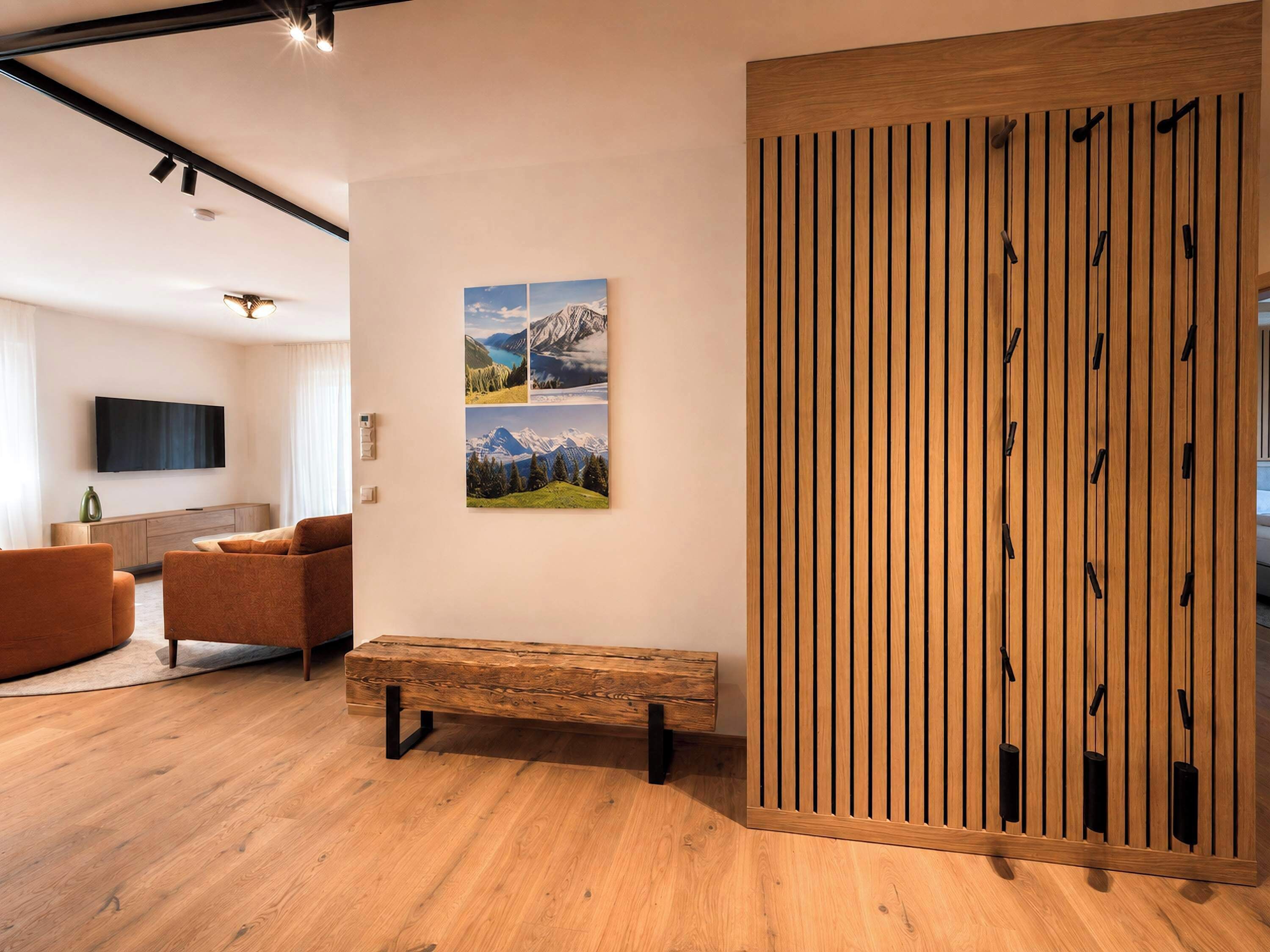 Un salon moderne avec un banc en bois, un téléviseur à écran plat et une étagère fixée au mur.