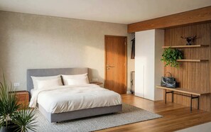 A modern bedroom with a bed, bedside tables, a wooden wall unit with shelves, and a potted plant.