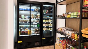 Et kølet køleskab med forskellige madvarer og en hylde med emballerede produkter.