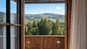 Ein hölzerner Balkon mit Blick auf eine bewaldete Berglandschaft.