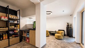 Un intérieur moderne comprenant un espace d’accueil, des sièges et un kiosque en libre-service.