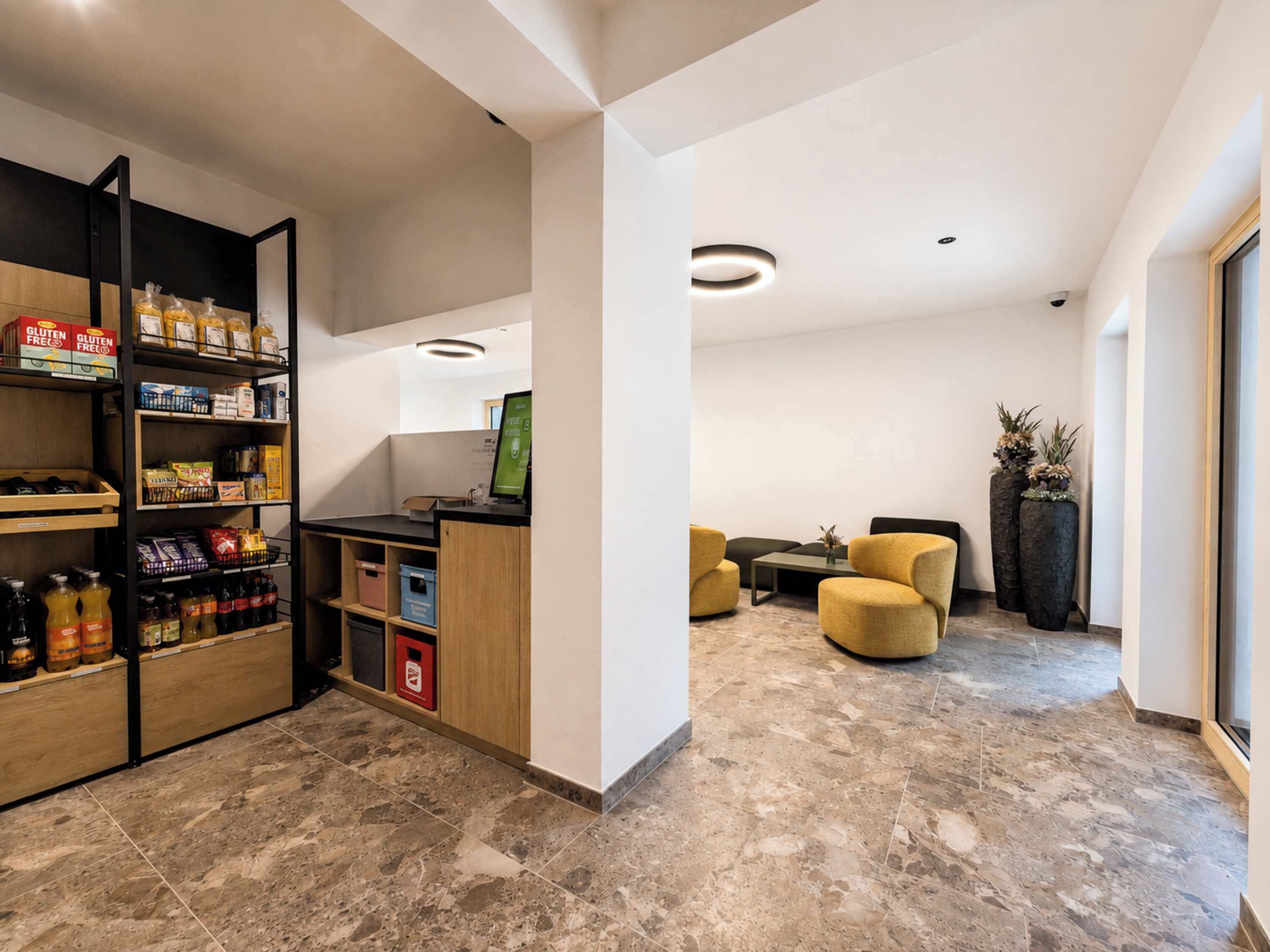 Un intérieur moderne comprenant un espace d’accueil, des sièges et un kiosque en libre-service.