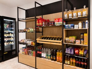 Ein Supermarkt mit Regalen voller Lebensmitteln, einer Kühltheke und einer Auswahl an abgefüllten Getränken.